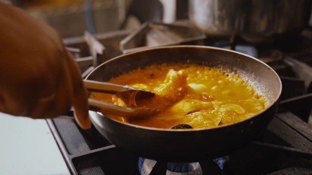 Lobster tails cooking in a sauce pan